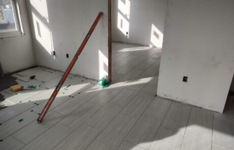 praiano-home-improvements-new-construction-bayshore-village-15 rectangular floor tile being set with spacers