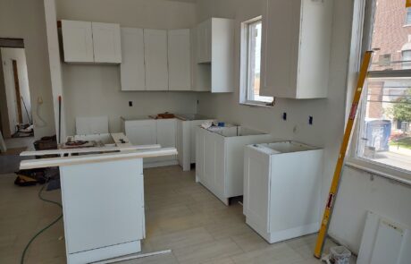 praiano-home-improvements-new-construction-bayshore-village-16 white kitchen cabinets being fitted in new construction unit